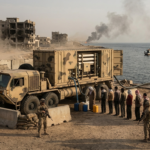 A military mobile water desalination truck operates in a war-torn coastal town, with soldiers guarding the complex system of pumps and filters. Local civilians queue with colorful jerrycans to receive purified water from the unit, while a sign in Arabic and English identifies the location as a "Mobile Water Point - Secured Zone."